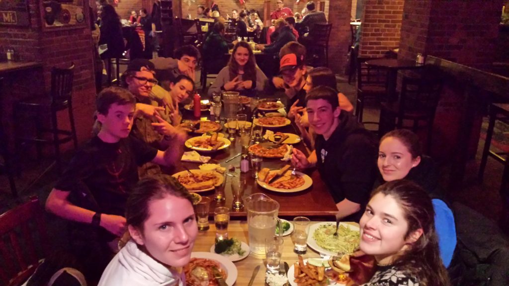 The gang at dinner flashing their favorite gang signs, because, teenagers